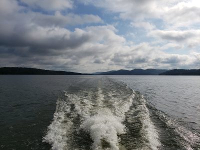 Lake Guntersville Alabama- Riding on a boat with a view of beautiful white clouds and blue skies with waves behind the boat